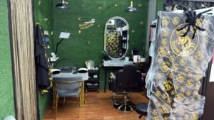 Zona de trabajo de barbería y peluquería con sillón, espejo y puesto de manicura